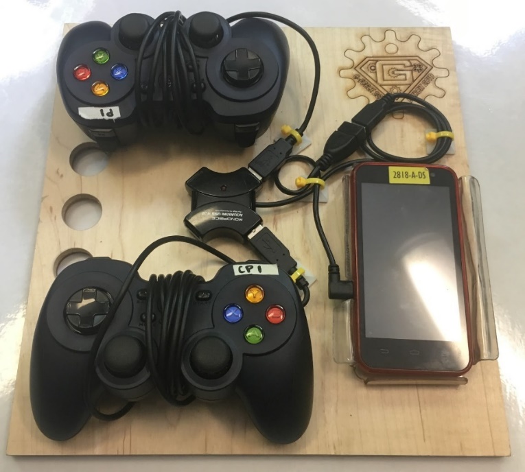 Two game controllers and a Robot Controller phone mounted on a plywood driver station board, connected through a USB hub.