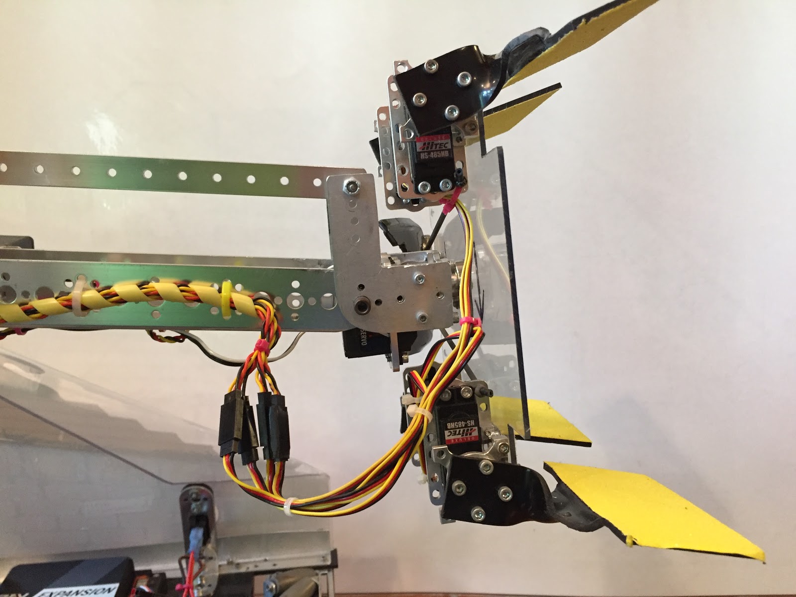 An orange spiral wire sheath wrapping a bundle of wires as it wraps around a robot arm joint.