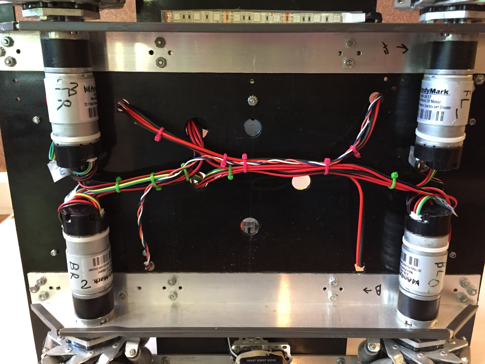A robotic claw mechanism with servo wires bundled and zip-tied along the arm.