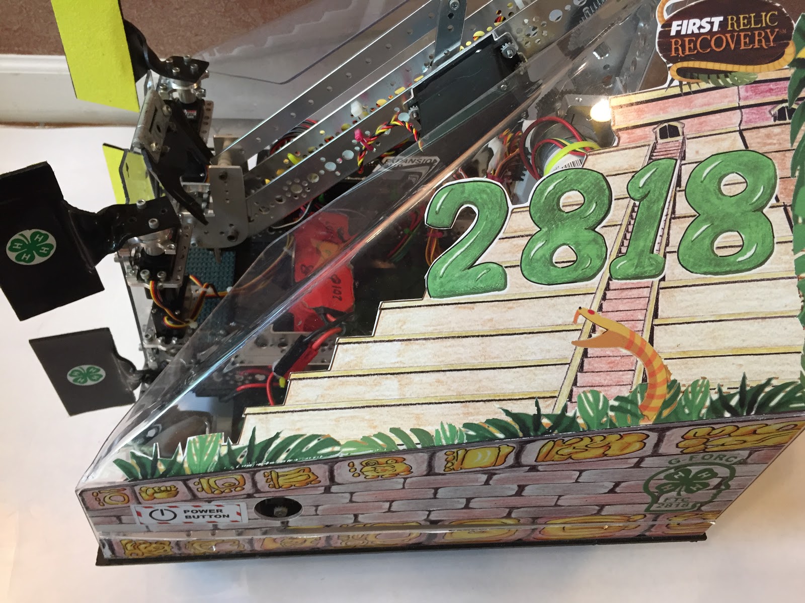 A robot with clear polycarbonate side shields decorated with team graphics, protecting the internal electronics and power switch.
