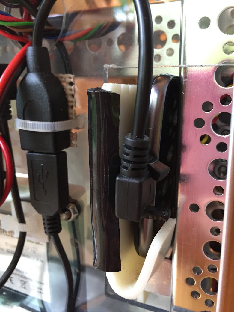 A USB cable secured with a black clamp and cable tie near the Control Hub.