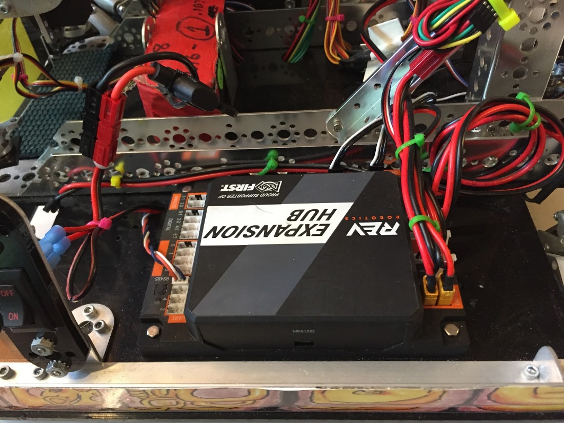 Four gearmotors mounted inside a robot chassis with power and encoder wires zip-tied into neat bundles routed across the frame.