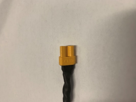 A male XT30 connector on a black and red wire.